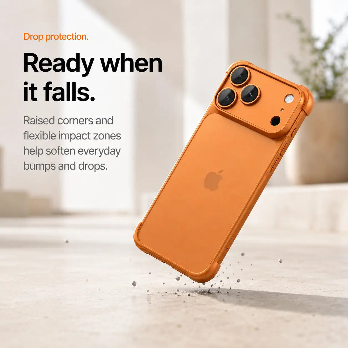 Orange phone bumper shown landing on a protected corner above a stone surface #color_Cosmic Orange